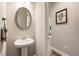 Stylish powder room featuring a pedestal sink, oval mirror, and decorative accents at 120 Maple Creek Way, Woodstock, GA 30188