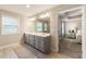 Bright bathroom with a double vanity, neutral paint, updated lighting, and a doorway to the main bedroom at 120 Maple Creek Way, Woodstock, GA 30188