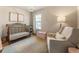 Cozy Bedroom with a crib, glider chair, toybox, modern lamp, and a soft rug at 120 Maple Creek Way, Woodstock, GA 30188