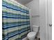 Clean bathroom with a toilet and a striped shower curtain at 279 Sturry Dr, Mcdonough, GA 30252