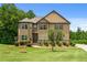 Charming two-story home featuring manicured lawn, detailed landscaping, and a circular driveway at 279 Sturry Dr, Mcdonough, GA 30252