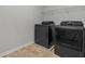 Laundry room featuring tile flooring and modern black washer and dryer units at 279 Sturry Dr, Mcdonough, GA 30252