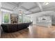 Open living space featuring a stone fireplace, hardwood floors, and seamless flow to kitchen at 279 Sturry Dr, Mcdonough, GA 30252