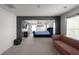 Open Primary bedroom featuring a tufted blue king bed, plush pink couch, and gray accent wall at 435 Noblewood Dr, Mcdonough, GA 30252