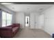 Living area with a plum couch, neutral carpet, and view down the hall toward bedrooms at 435 Noblewood Dr, Mcdonough, GA 30252