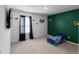 bedroom with a blue toddler bed, neutral carpet, and green accent wall with play-themed decor at 435 Noblewood Dr, Mcdonough, GA 30252