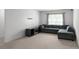 Comfortable living area featuring plush gray sectional sofa, neutral carpet, and natural light from the window at 435 Noblewood Dr, Mcdonough, GA 30252