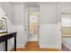 Hallway with hardwood floors leads to a well-lit bathroom with white tile and modern fixtures at 798 Saint Charles Ne Ave # 7, Atlanta, GA 30306