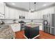 Kitchen featuring white cabinets, granite countertops, stainless steel appliances, and a central island at 920 Pebblestone Ct, Alpharetta, GA 30009