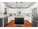 Modern kitchen featuring white cabinets, stainless steel appliances, hardwood floors, and a central island at 920 Pebblestone Ct, Alpharetta, GA 30009