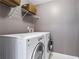 Laundry room with large capacity washer and dryer units, wire rack shelving, and tile floors at 920 Pebblestone Ct, Alpharetta, GA 30009