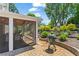 Paver patio with outdoor grill and sunroom, surrounded by beautiful landscaping and mature trees at 920 Pebblestone Ct, Alpharetta, GA 30009
