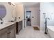 Bright bathroom featuring double sinks with a freestanding tub and large shower in the background at 1004 Spruce Creek Ln, Lawrenceville, GA 30045