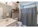 Neutral bathroom with floating shelves, framed art, and shower with gray curtain at 1004 Spruce Creek Ln, Lawrenceville, GA 30045