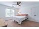 Well-lit bedroom with neutral decor, a ceiling fan, and a large window with natural light at 1004 Spruce Creek Ln, Lawrenceville, GA 30045