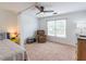 Neutral bedroom with a ceiling fan, reading chair, and a large window for natural light at 1004 Spruce Creek Ln, Lawrenceville, GA 30045