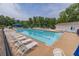 Community pool with clear blue water, lounge chairs and a blue canopy at 1004 Spruce Creek Ln, Lawrenceville, GA 30045