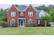 Beautiful two-story red brick home with well-manicured lawn and black shutters at 1004 Spruce Creek Ln, Lawrenceville, GA 30045