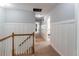 Bright hallway with neutral decor, white wainscoting, and natural light coming through open bedroom doors at 1004 Spruce Creek Ln, Lawrenceville, GA 30045