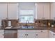 Kitchen featuring light colored cabinets, granite countertops, stainless steel appliances, and a window at 1004 Spruce Creek Ln, Lawrenceville, GA 30045