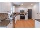 Well-lit kitchen features updated cabinets, stainless steel appliances, and granite countertops at 1004 Spruce Creek Ln, Lawrenceville, GA 30045