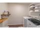 Bright laundry room featuring wood shelving, washer, and dryer at 1004 Spruce Creek Ln, Lawrenceville, GA 30045
