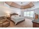 Elegant main bedroom featuring a tray ceiling, large windows, and traditional-style furniture at 1004 Spruce Creek Ln, Lawrenceville, GA 30045