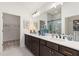 Bathroom with a double sink vanity, dark cabinets, and a view into the walk-in closet and shower at 1307 Cedarcrest Blvd, Acworth, GA 30101