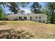 Home's back exterior showcasing a patio area, large yard, and traditional architecture at 250 Hembree Rd, Roswell, GA 30075