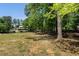Expansive backyard with mature trees and a partial view of another house in the distance at 250 Hembree Rd, Roswell, GA 30075