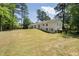 Spacious backyard featuring a well-manicured lawn, wooden fence, and lush trees at 250 Hembree Rd, Roswell, GA 30075