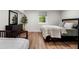 A charming bedroom with neutral tones, a serene window view, and stylish furnishings with hardwood floors at 250 Hembree Rd, Roswell, GA 30075