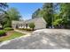 Charming one-story home featuring a wide driveway, manicured lawn, and attached garage at 250 Hembree Rd, Roswell, GA 30075