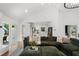 Bright, open living room featuring a large green couch and an open flow into the kitchen at 250 Hembree Rd, Roswell, GA 30075