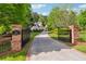 Long driveway featuring a gate, address sign, and manicured landscaping leads to a stunning home at 5122 Cantrell Se Pt, Acworth, GA 30101