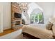 This main bedroom features a brick fireplace, a high ceiling, and a large window at 5122 Cantrell Se Pt, Acworth, GA 30101