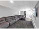 Finished basement with a large sectional couch, and mounted TV at 7371 Ovis Ct, Riverdale, GA 30274