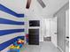 Playful bedroom with blue striped walls and space for a dresser and toys at 7371 Ovis Ct, Riverdale, GA 30274
