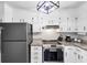 Bright kitchen features white cabinetry, stainless steel appliances, and granite countertops at 7371 Ovis Ct, Riverdale, GA 30274
