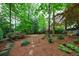 Serene backyard with lush landscaping and an assortment of trees, plants and lawn ornaments at 1412 Lanier Ne Mnr, Atlanta, GA 30319