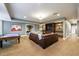 Finished basement featuring a large seating area with a brown leather couch and a pool table in the background at 1412 Lanier Ne Mnr, Atlanta, GA 30319