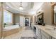 Bright bathroom featuring a soaking tub, dual sinks with neutral countertops, and luxury tile at 1412 Lanier Ne Mnr, Atlanta, GA 30319
