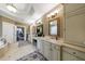 Spacious bathroom featuring dual sinks with neutral countertops, luxury tile, and a soaking tub at 1412 Lanier Ne Mnr, Atlanta, GA 30319