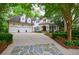 Stunning white brick home featuring a three-car garage and beautifully landscaped front yard at 1412 Lanier Ne Mnr, Atlanta, GA 30319