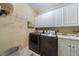Functional laundry room with white cabinets, modern machines, and efficient storage at 1412 Lanier Ne Mnr, Atlanta, GA 30319