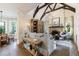 Cozy living room with wood floors, exposed beams, fireplace, and view to dining area at 1412 Lanier Ne Mnr, Atlanta, GA 30319