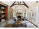 Inviting living room featuring a stone fireplace, exposed beams, and custom built-ins for storage at 1412 Lanier Ne Mnr, Atlanta, GA 30319