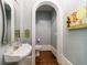 Charming powder room features pedestal sink, mirror, and hardwood floors at 1412 Lanier Ne Mnr, Atlanta, GA 30319