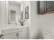 Clean powder room with white vanity, modern fixtures, framed artwork, and toilet at 241 Maynard Se Ter # 18, Atlanta, GA 30316