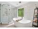 Luxurious bathroom featuring a modern stand alone tub, separate glass shower, and bright window at 4013 Dover Ave, Alpharetta, GA 30009